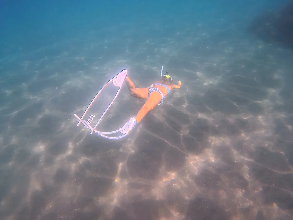 白い砂地が見えるほど澄んだ海の中をゆく素潜りの様子