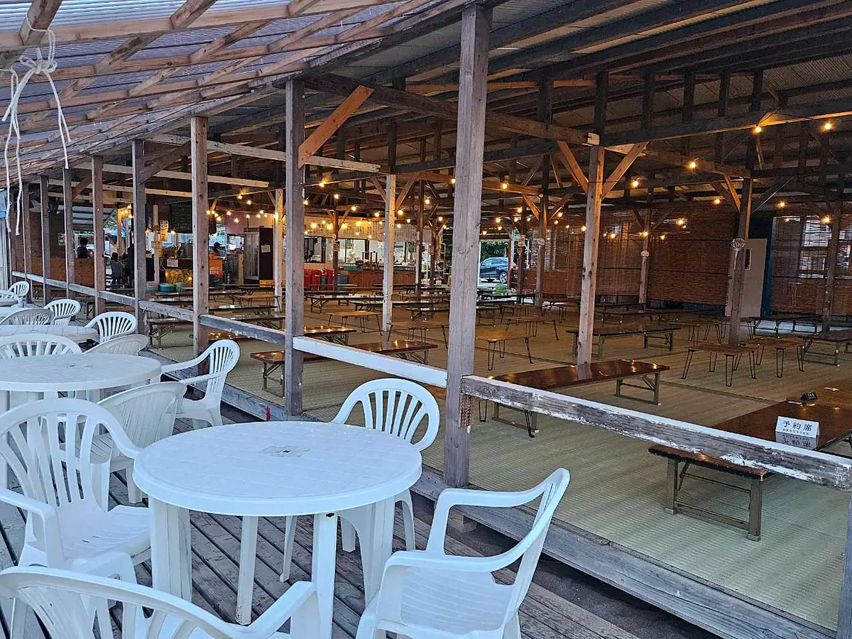 灯りがともる夜のタローズビーチ店内。座敷席とテラス席